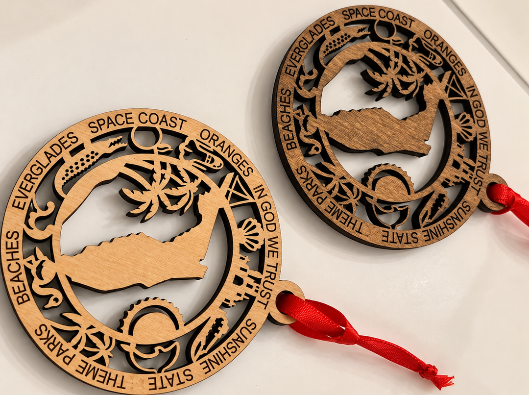 Two round laser-cut wooden coast guard ornaments with red hanging ribbons, displayed on a white background.