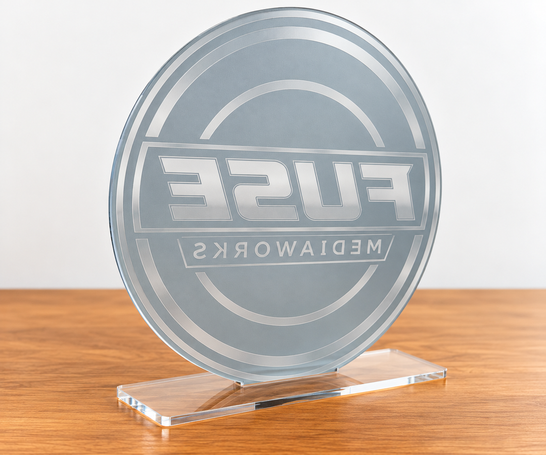 A round clear acrylic award plaque featuring the text &
